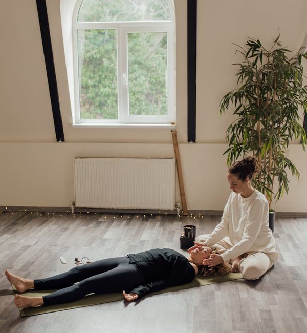 Teenager sitting calmly in a meditation pose by a window.